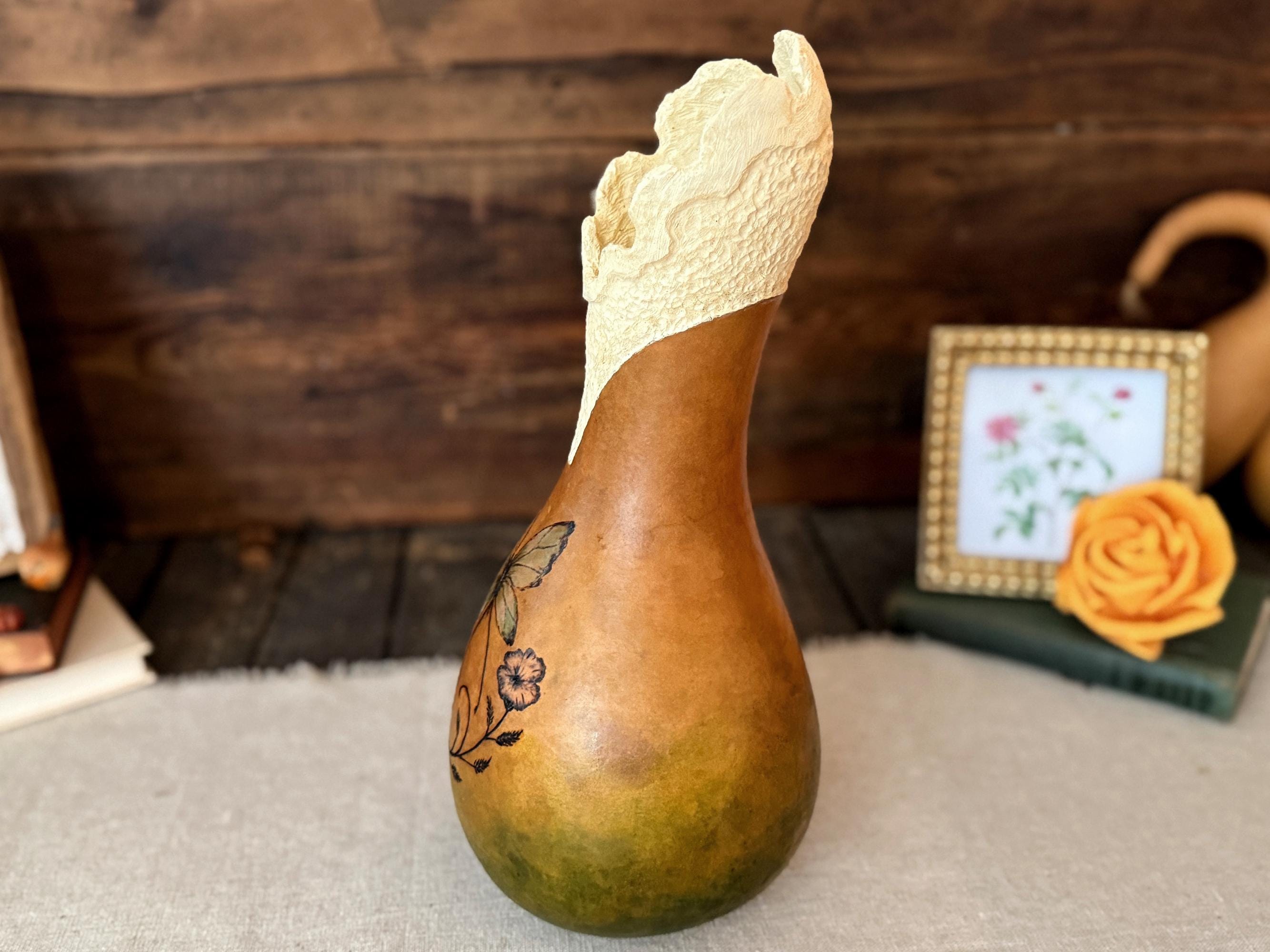 Decorative gourd with a floral design on a wooden surface