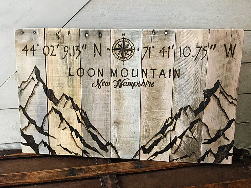 Wooden sign with mountain design and coordinates of Loon Mountain, New Hampshire.