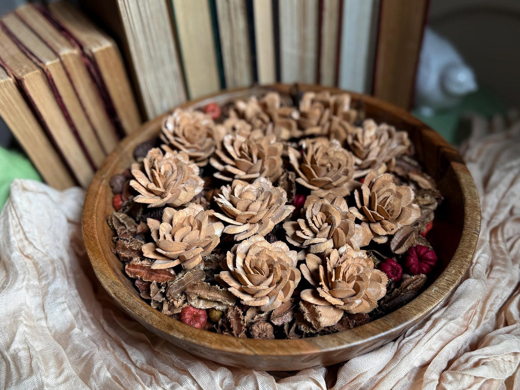 Wooden bowl filled with dried flowers on a textured surface