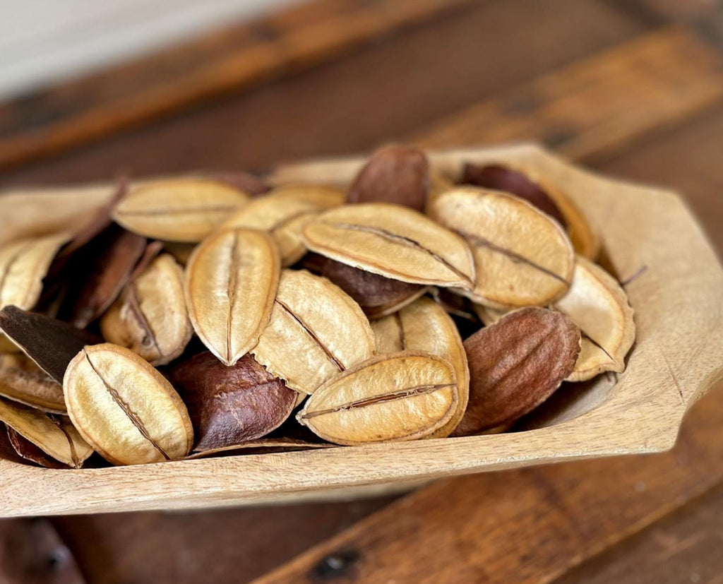 natural tan leaves in a wooden bowl on a wooden surface