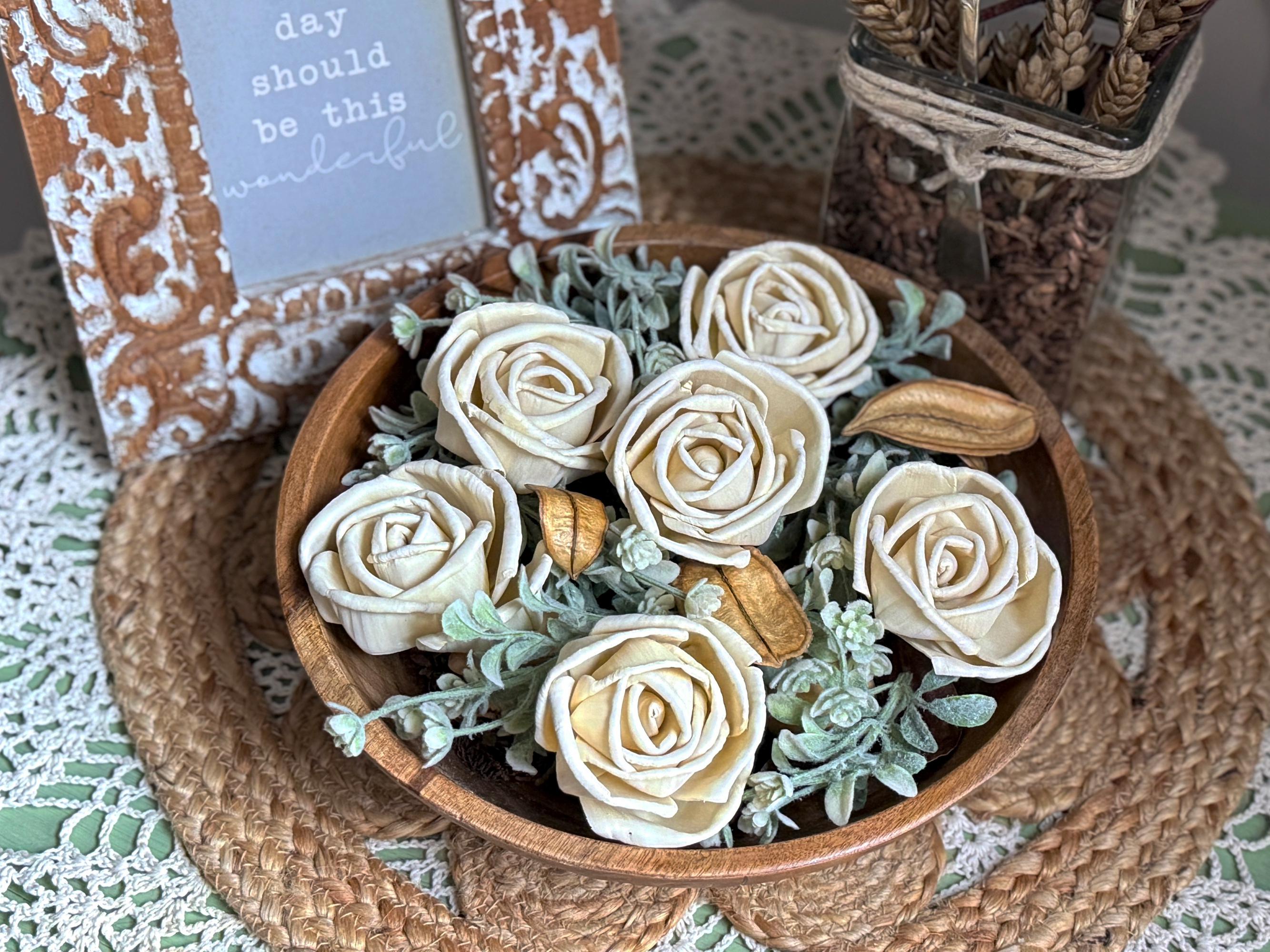 Teak Wood bowl with decorative wood roses on a textured surface