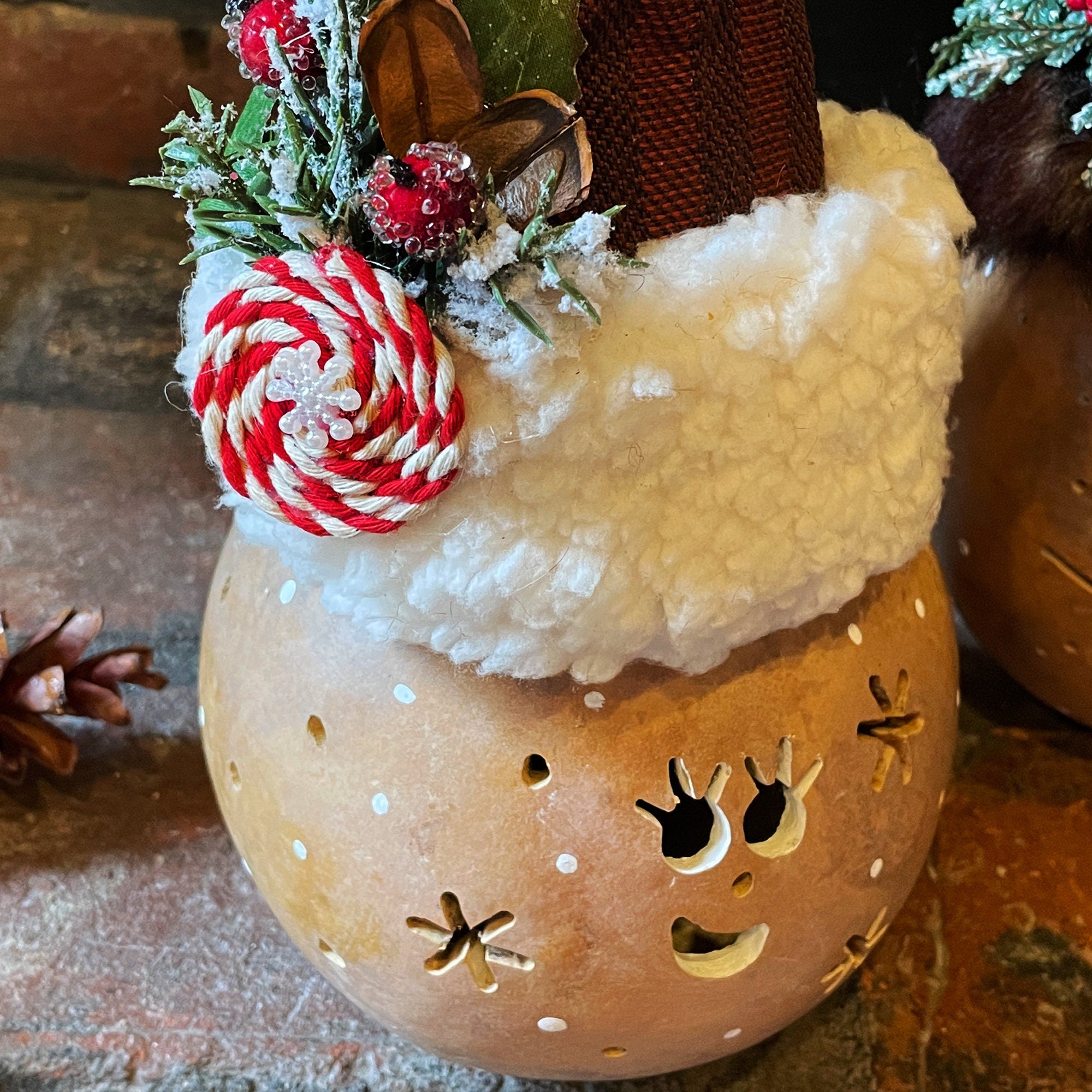 Decorative reindeer ornament with a candy cane antler on a rustic background