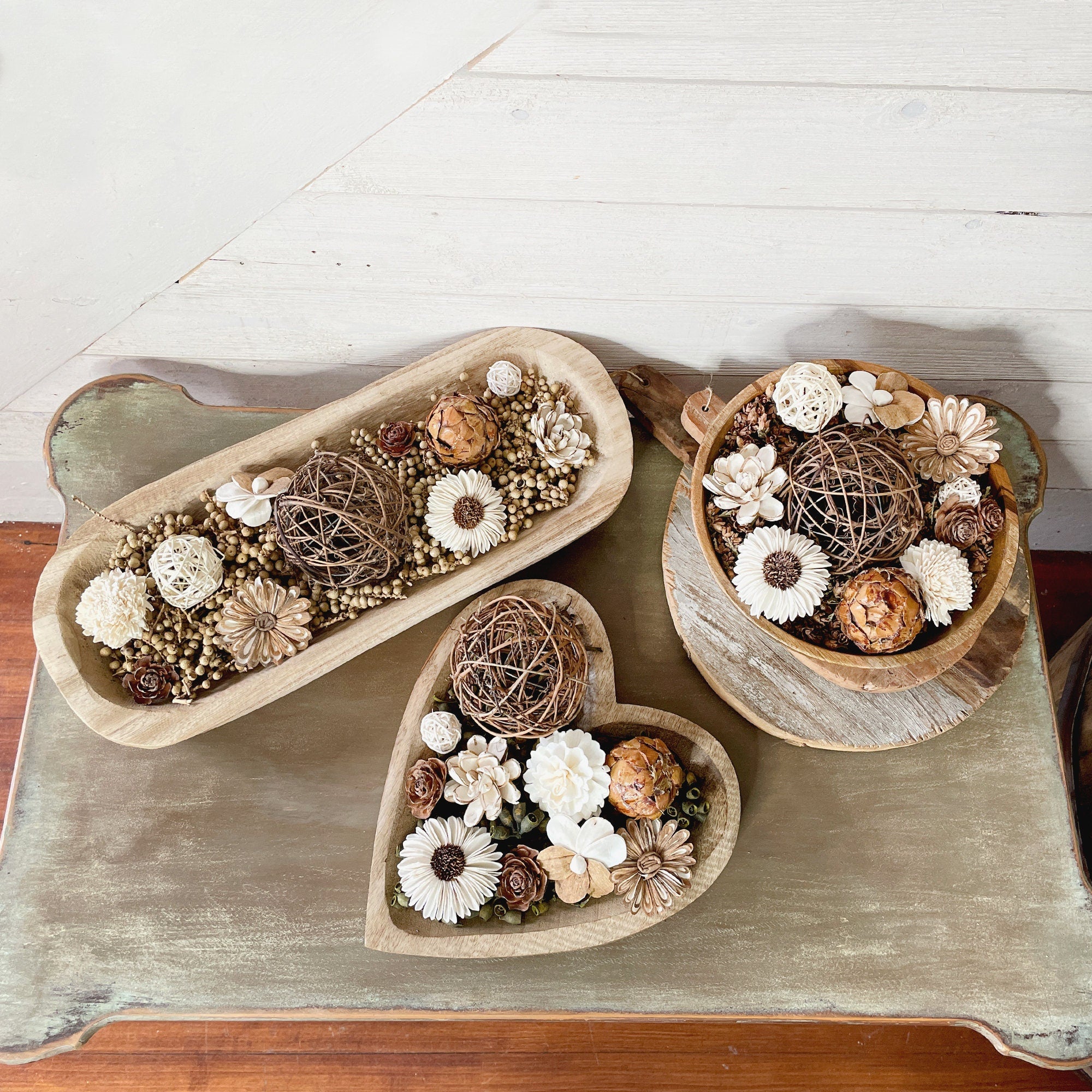Decorative bowls with floral and natural elements on a wooden surface
