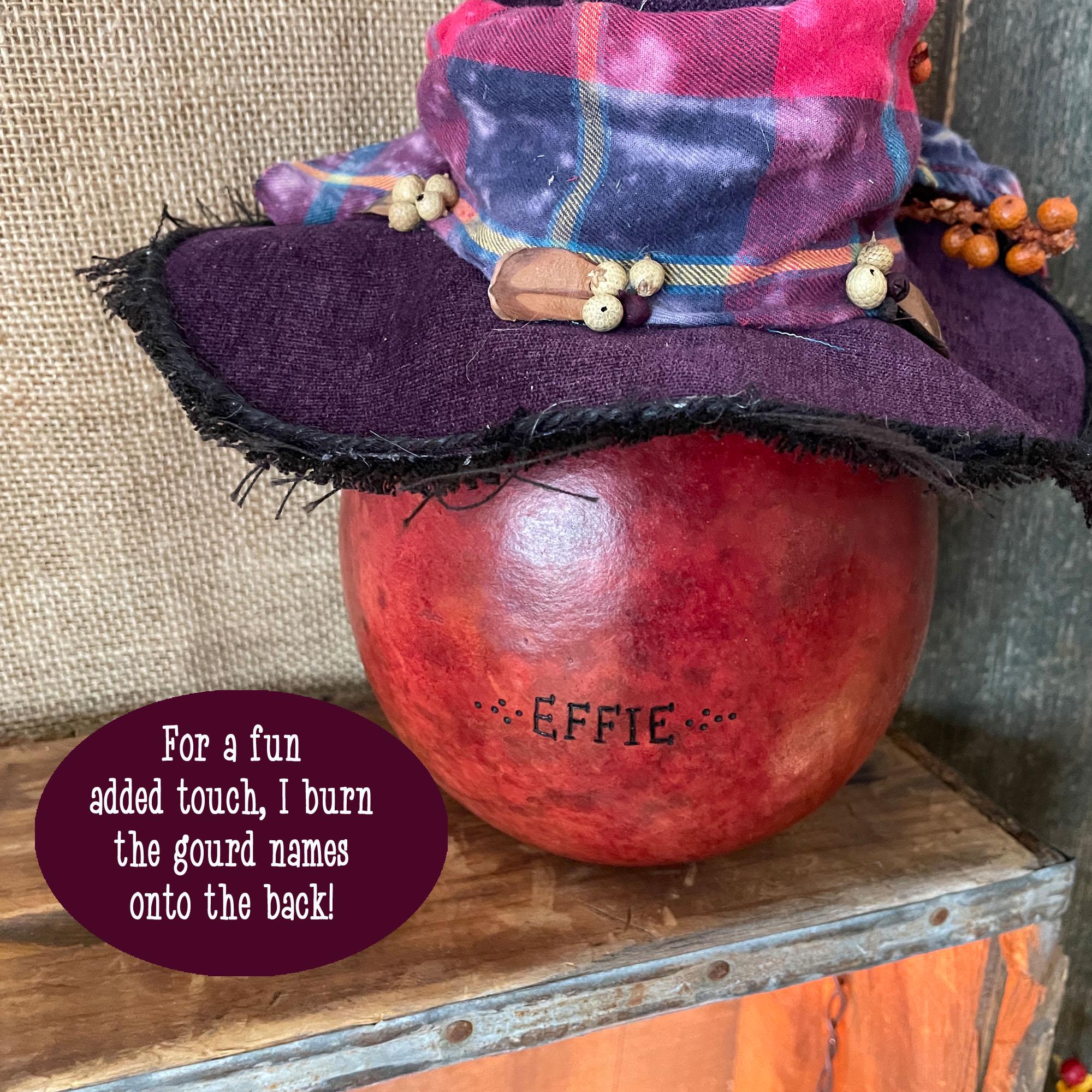 Decorative gourd with a colorful hat on a wooden surface, featuring text about gourd names.