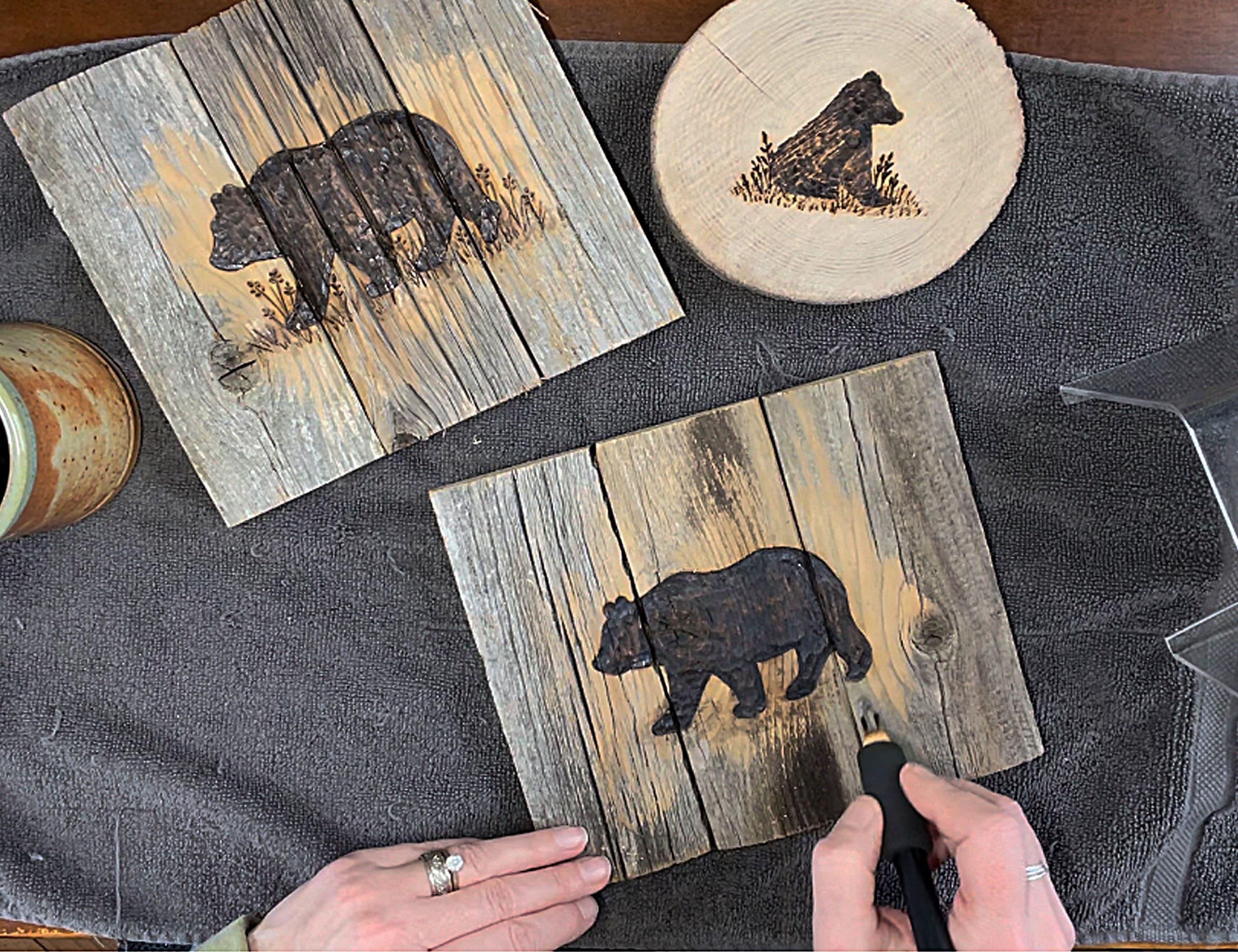 Front wall of wooden box with bear design on a dark surface