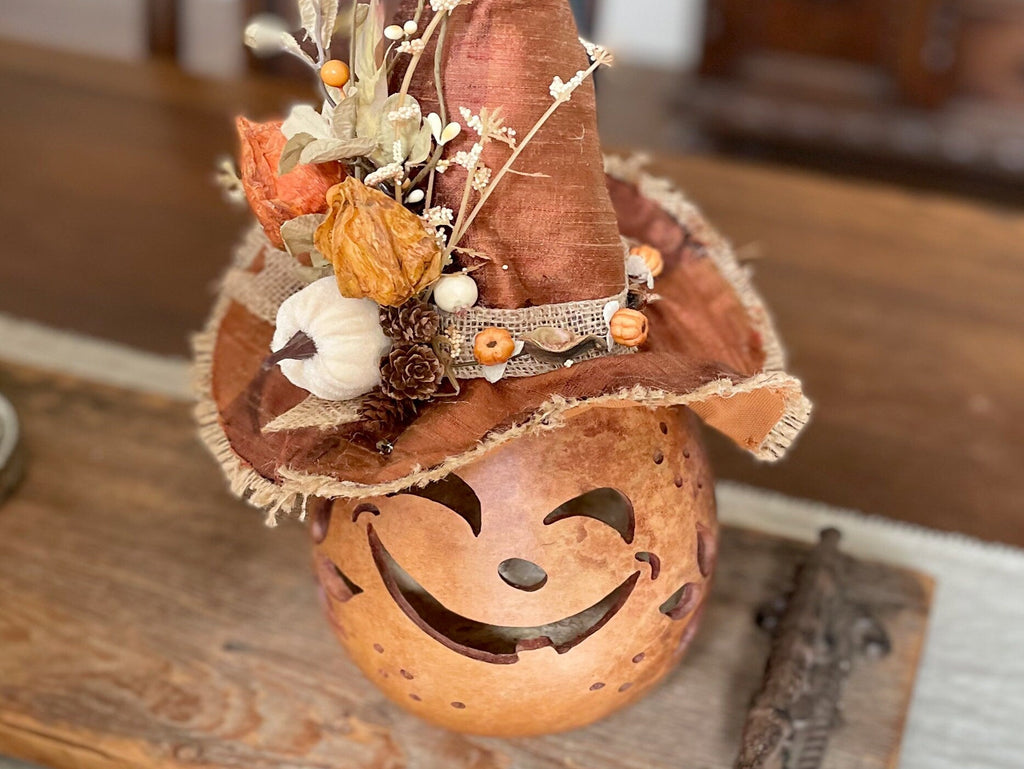 Decorative pumpkin with a face and autumn-themed top hat on a wooden surface, featuring the Etsy store 'boutiquebarn'.