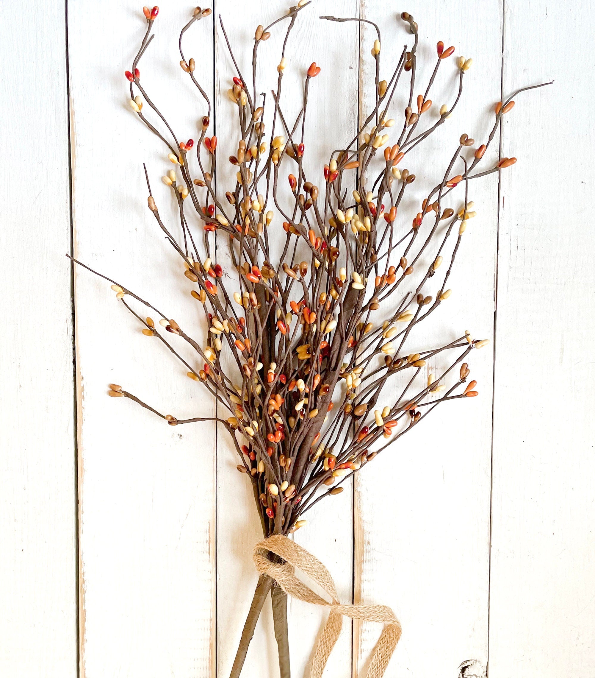 Decorative bundle of branches with small berries tied with burlap ribbon on a white wooden background, featuring the Etsy store 'boutiquebarn.etsy.