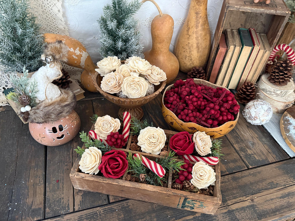 Decorative setup with flowers, berries, and wooden elements on a rustic wooden surface.