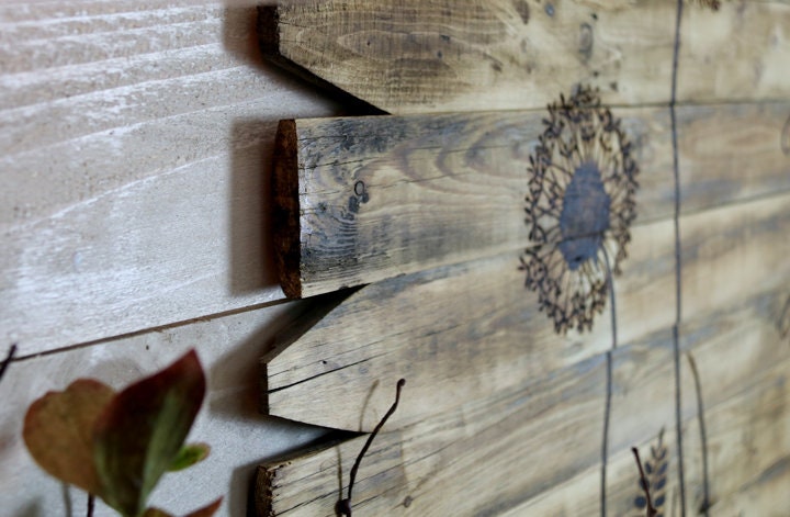Wooden wall art with floral patterns on a textured wall