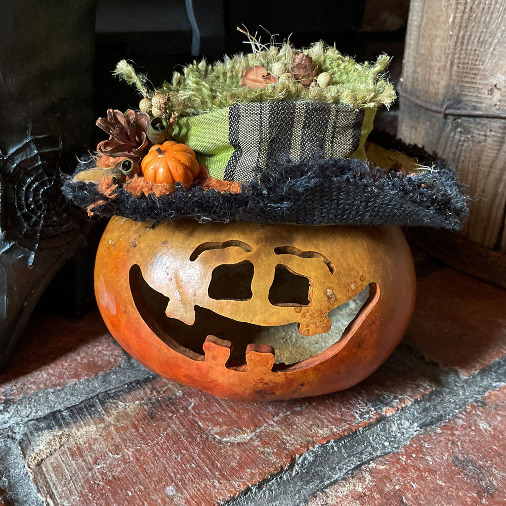 Decorative pumpkin with a face cutout on a rustic surface