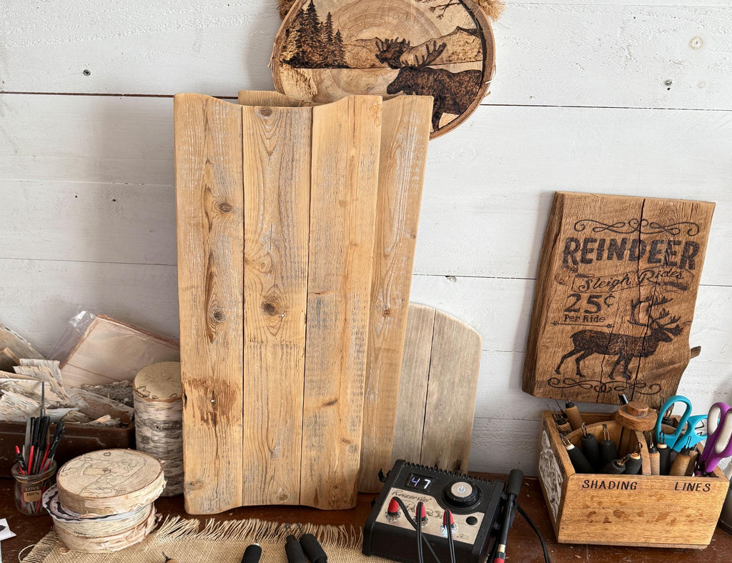 Wooden cutting boards and rustic decor items on a white wooden surface