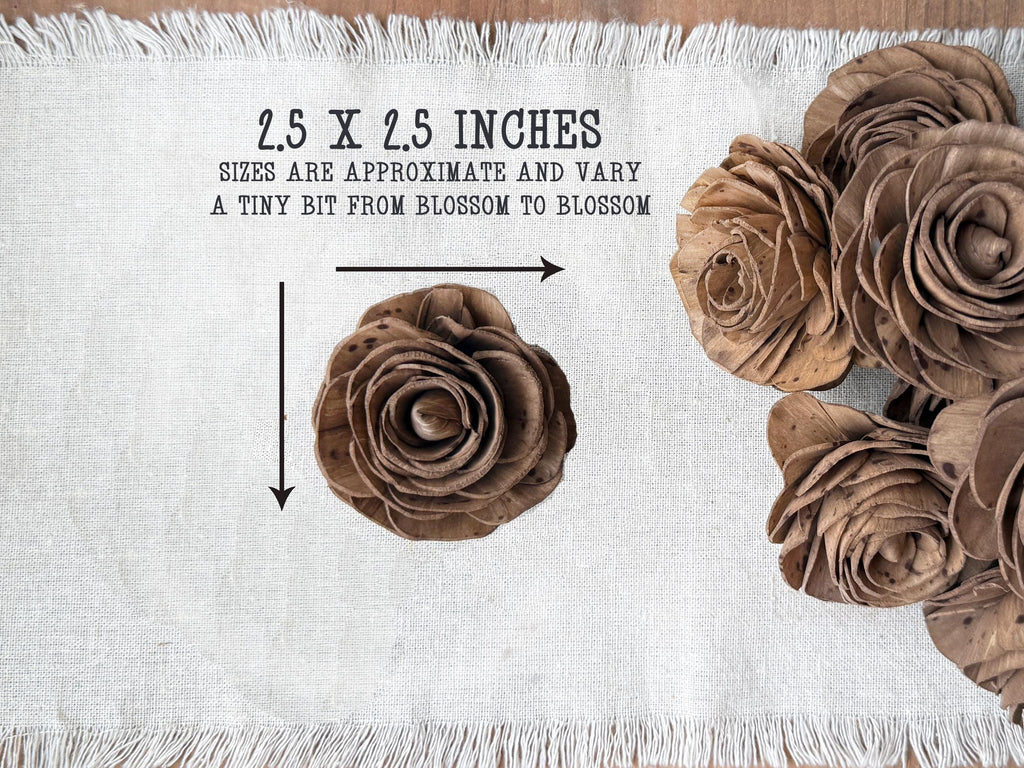 Brown paper flowers on a white fabric background with measurements and text.