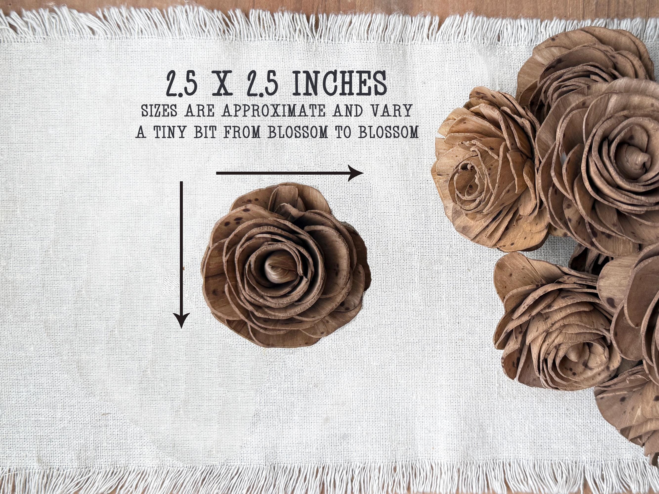 Brown paper flowers on a white fabric background with measurements and text.