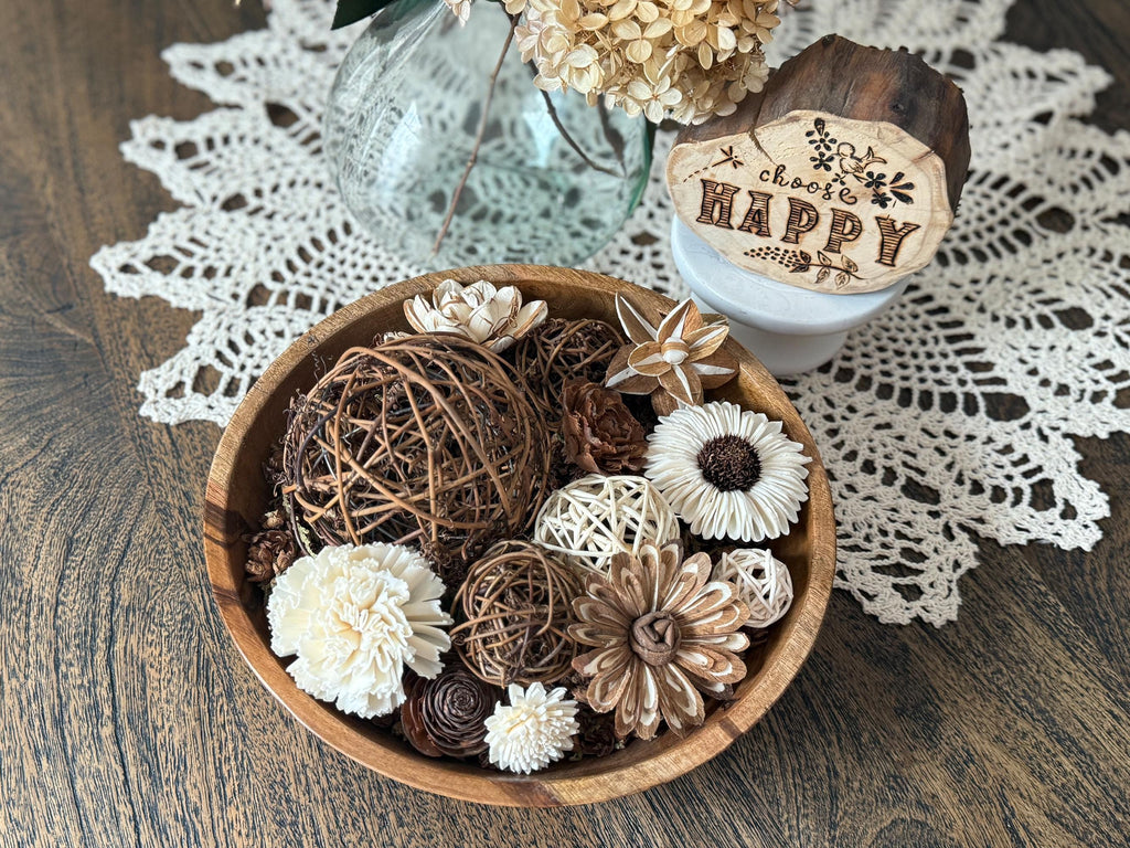 Decorative wood bowl with flowers and a wooden block on a doily