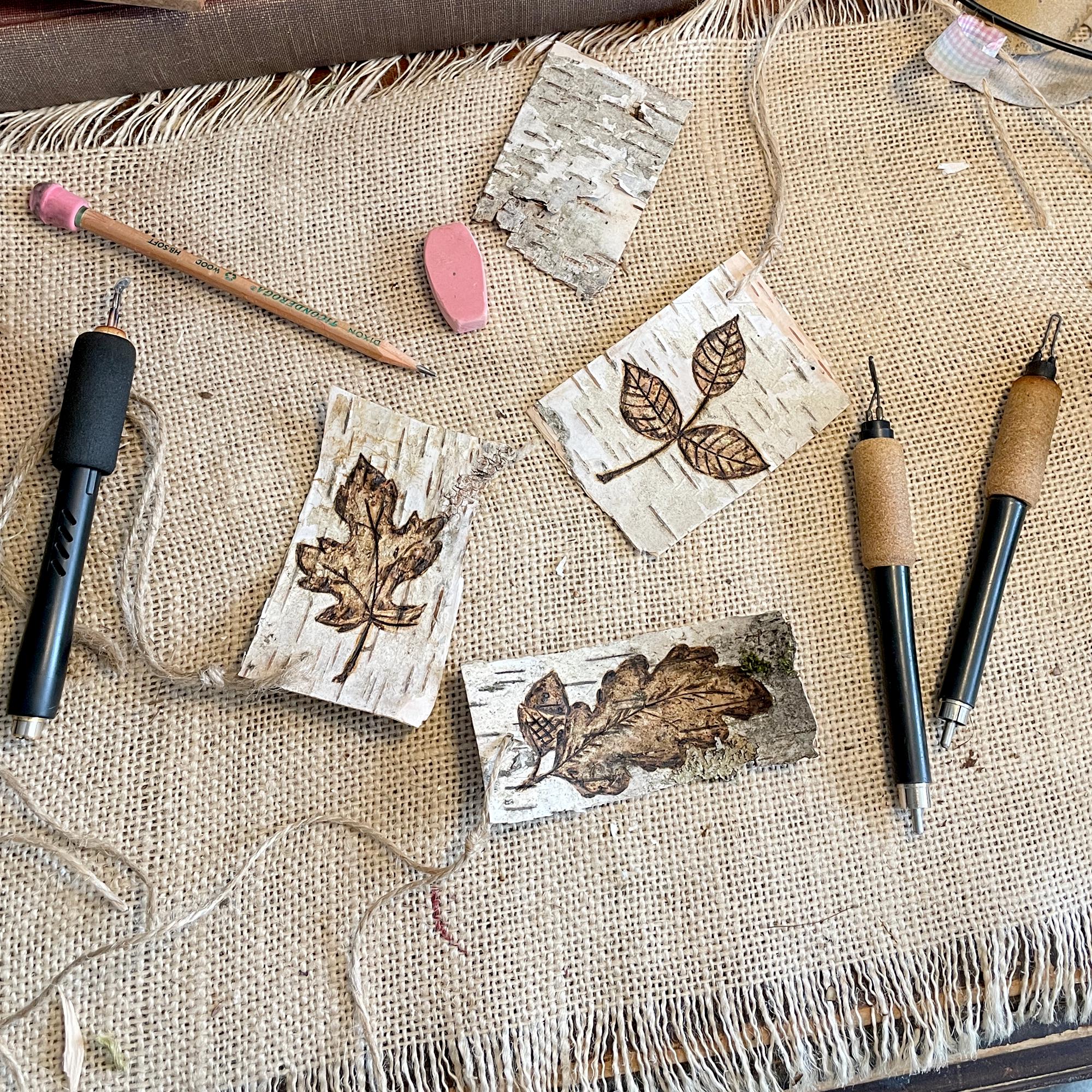 Wooden present toppers with leaf designs on a textured fabric surface with carving tools.