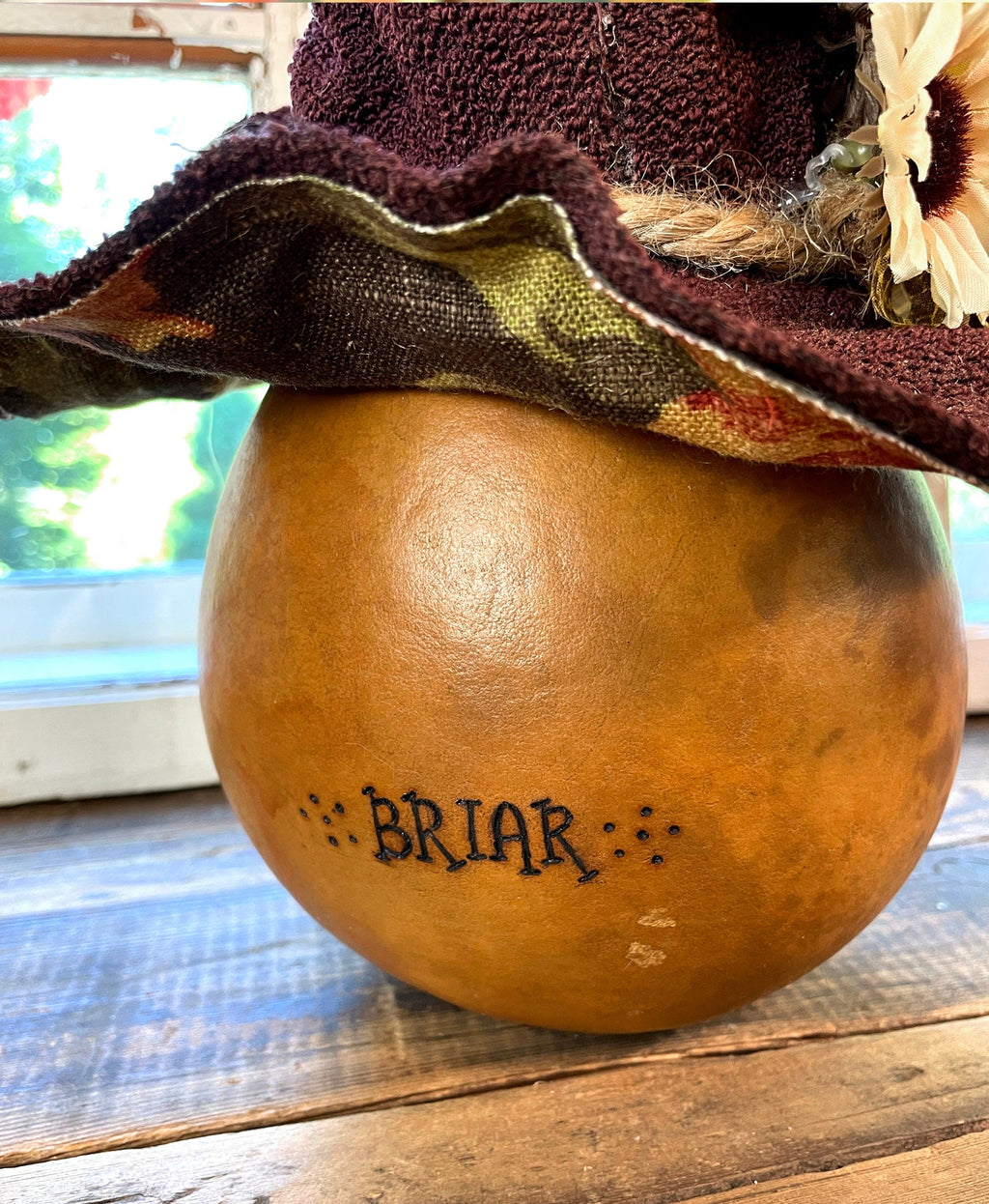 Gourd with 'BRIAR' engraving on a wooden surface