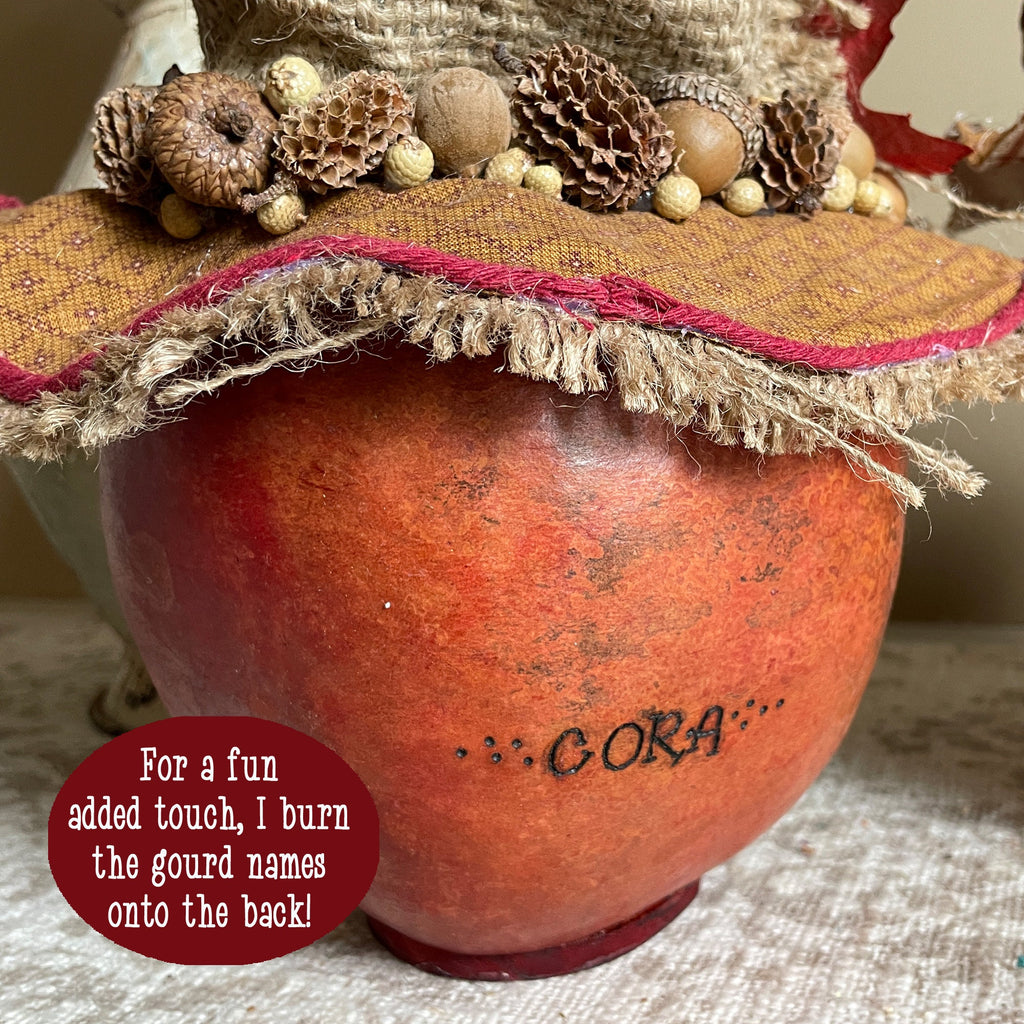 Decorative gourd with autumn elements and 'Gora' branding.