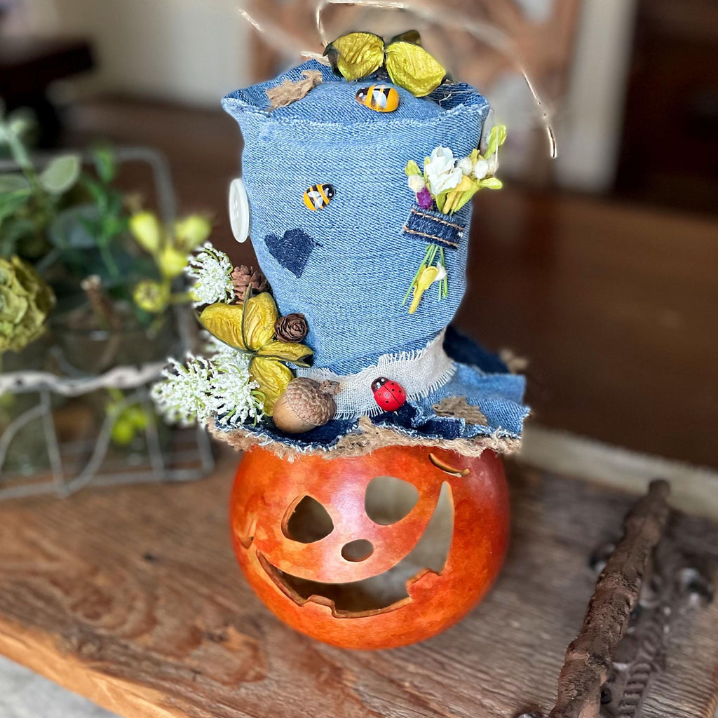 Decorative item with denim top and pumpkin base on a wooden surface