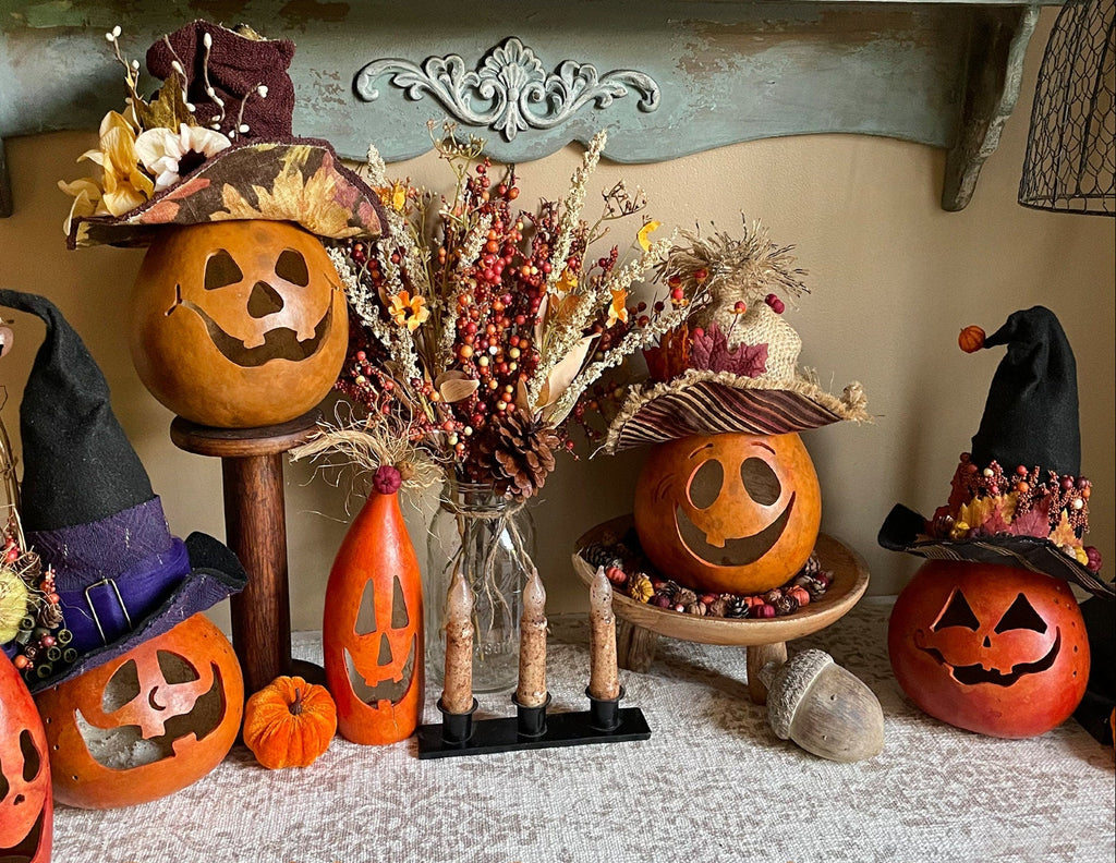 Halloween-themed decorations with pumpkins, hats, and decorative elements on a shelf.
