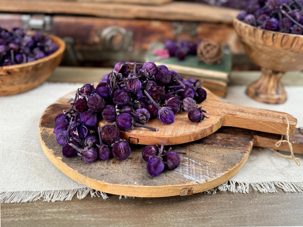 Purple dried flowers on a wooden cutting board with a rustic background