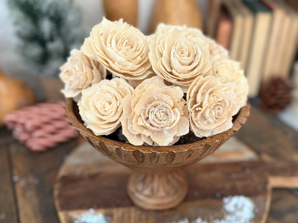 Decorative vase with beige flowers on a wooden surface