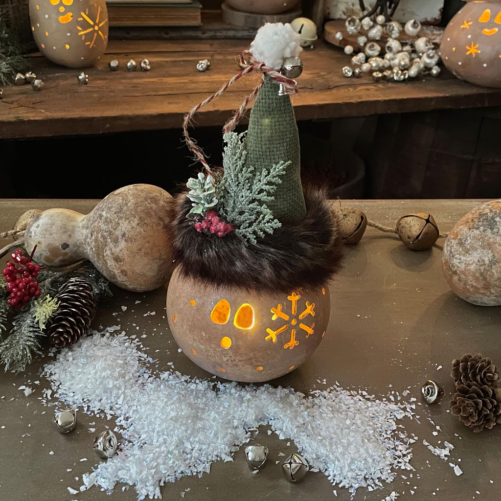Hand-carved gourd Christmas elf with snowflake accents and natural gourd texture