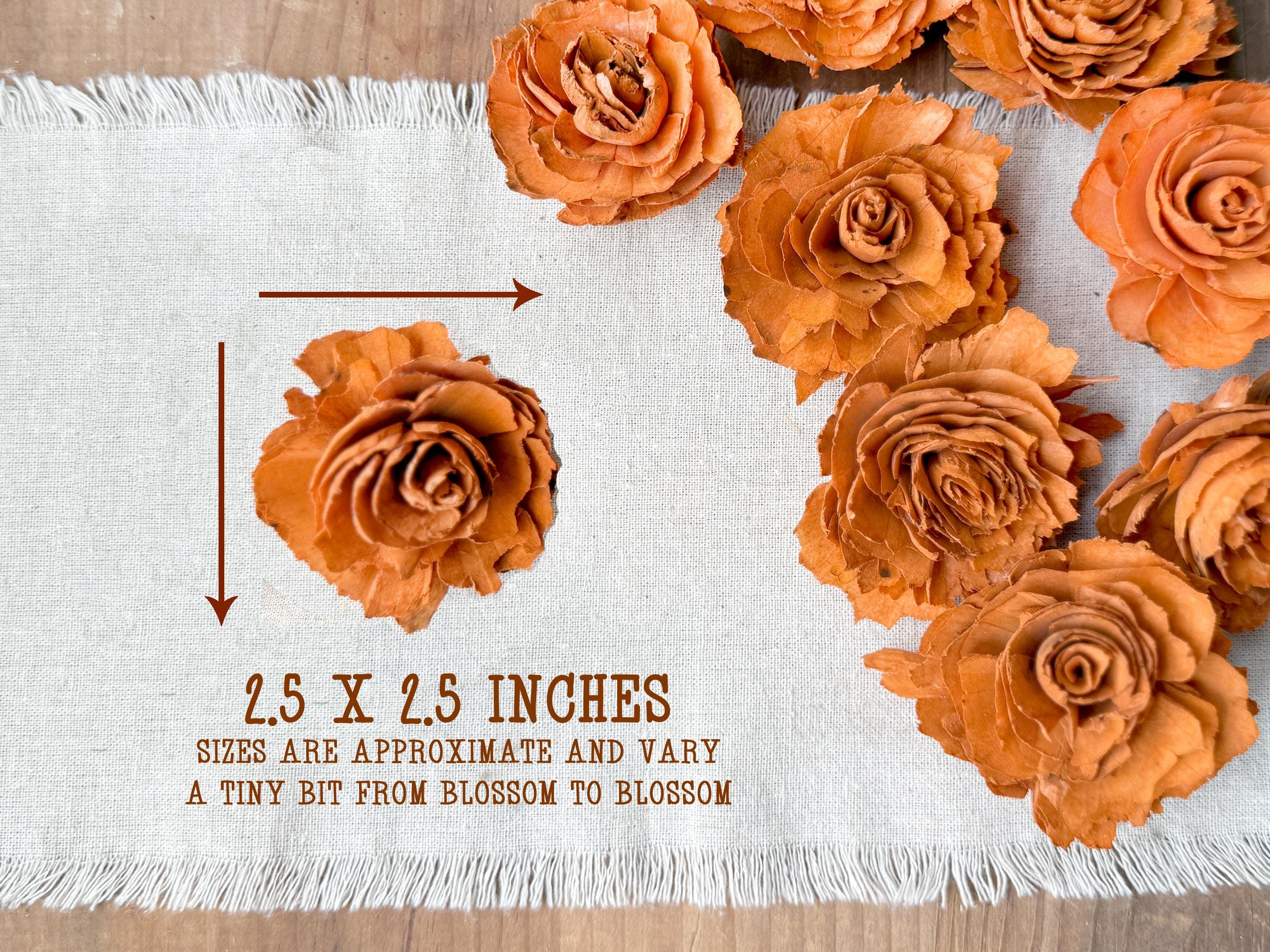 Orange flowers arranged on a white fabric with measurement text.