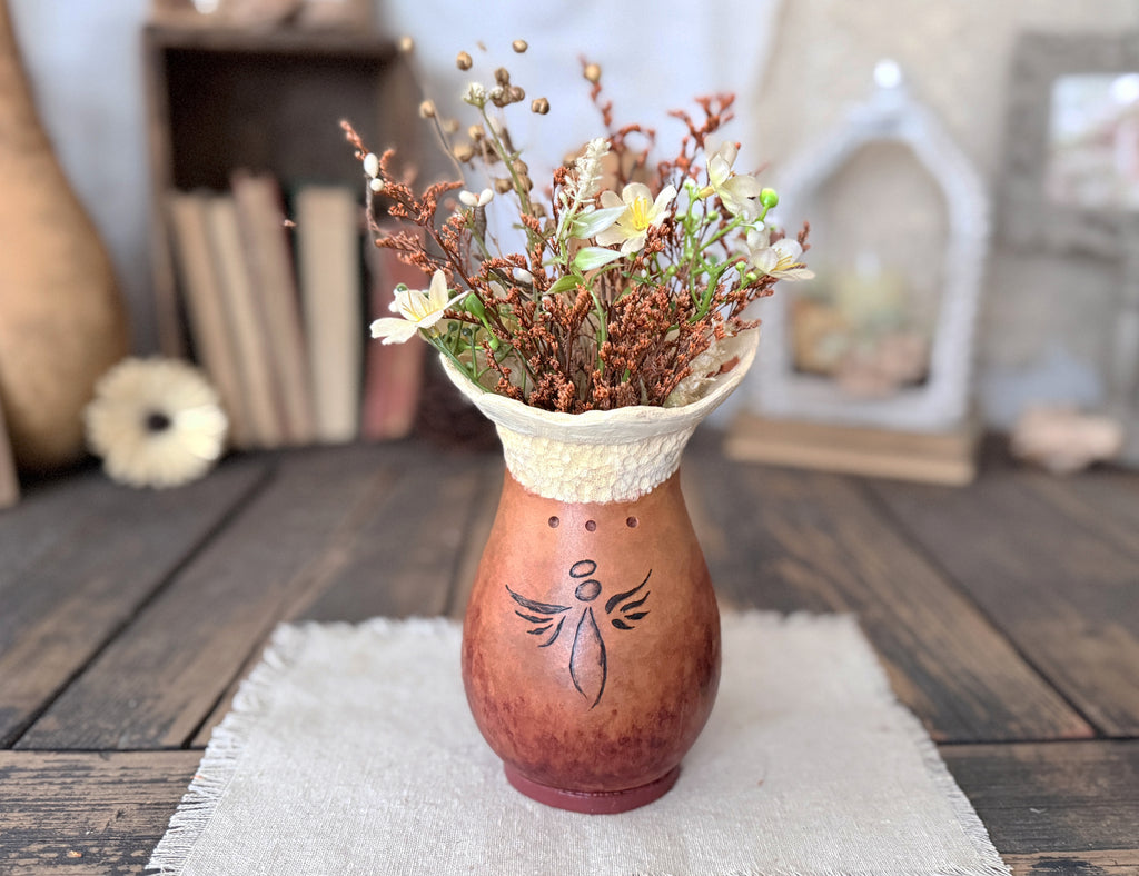Decorative Angel gourd vase with floral arrangement on a wooden table