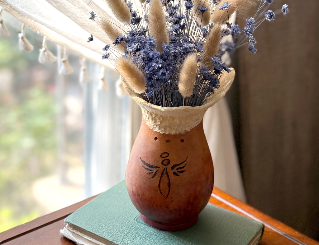 Gourd Vase with dried flowers on a table next to a window