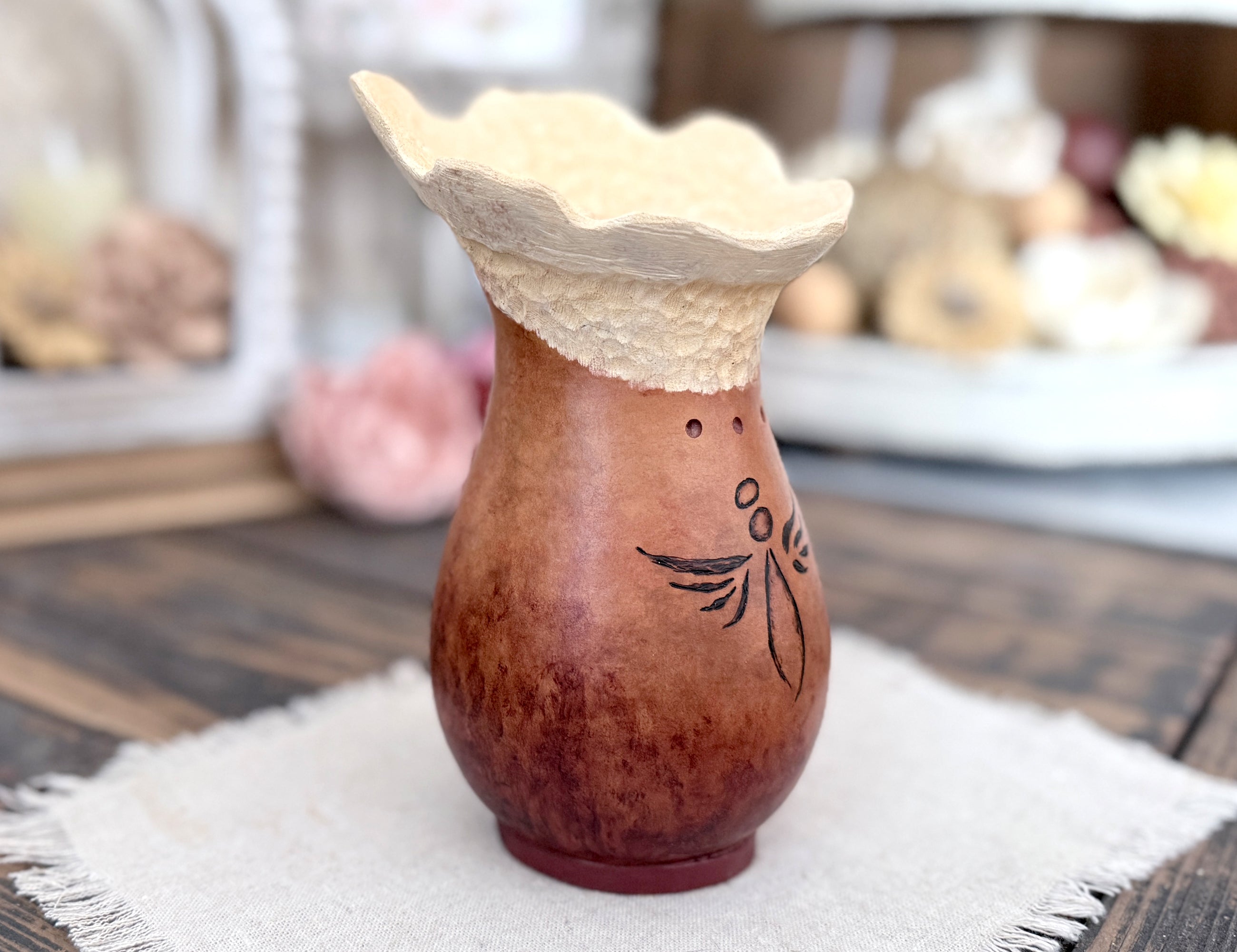 A profile of the gourd vase showing the curve outward on the carved rim.