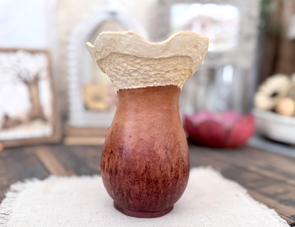 The back view of a gourd vase with textured top on a surface