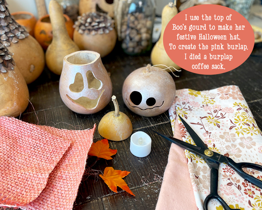 A work table shows the supplies used to decorated the handmade pink ghost decorations.