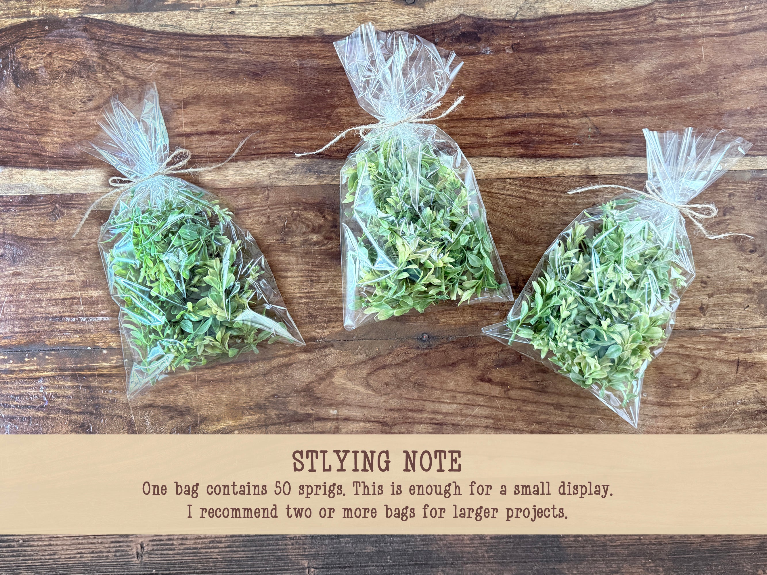 Three bags of faux greenery on a wooden surface with text below.