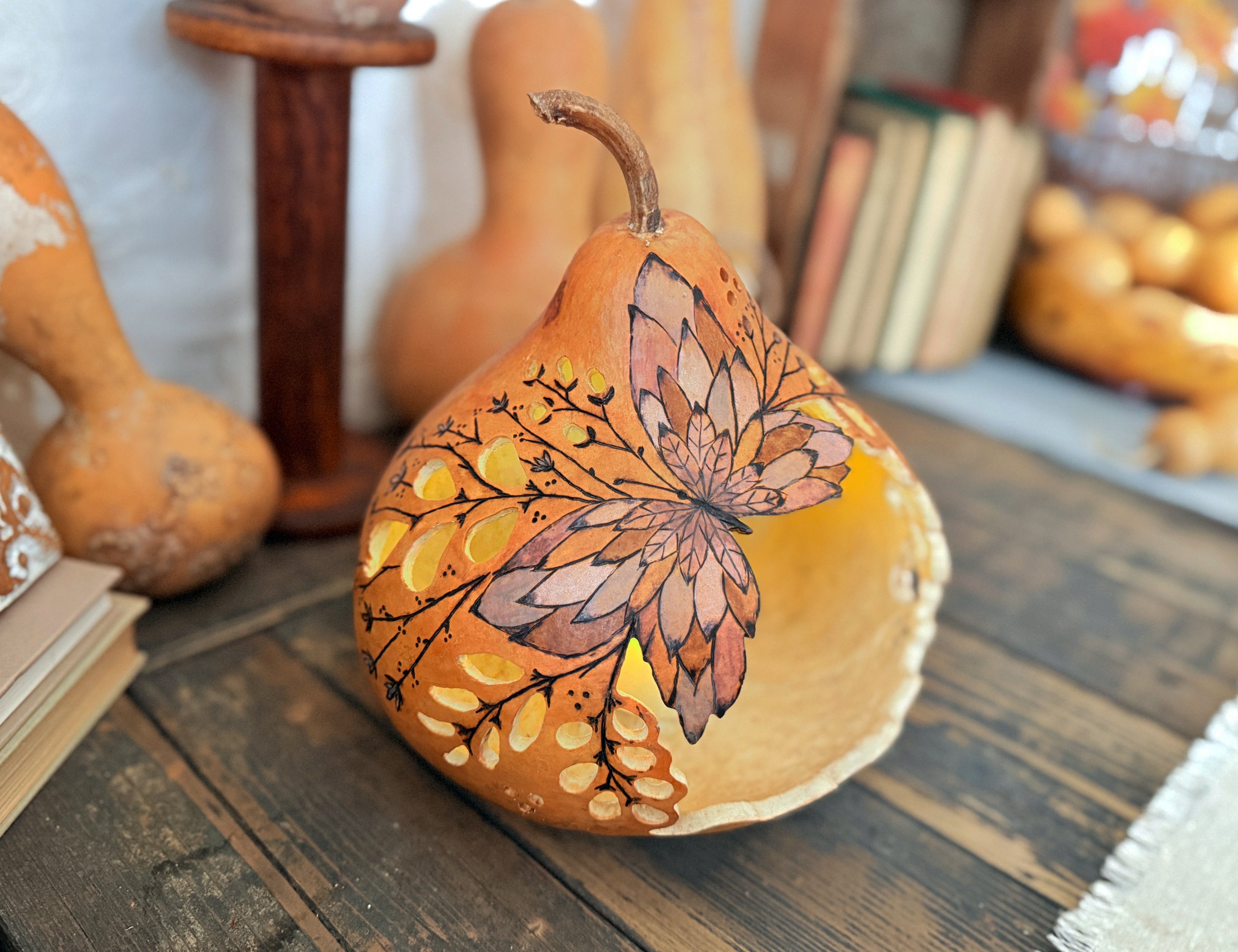 Side view of gourd light showing the hand drawn butterfly with lacy cut out design