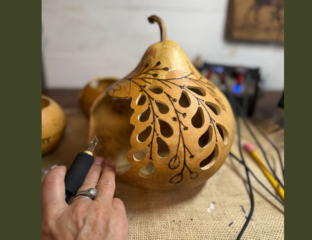 Gourd getting branch and leaves artwork burned into shell