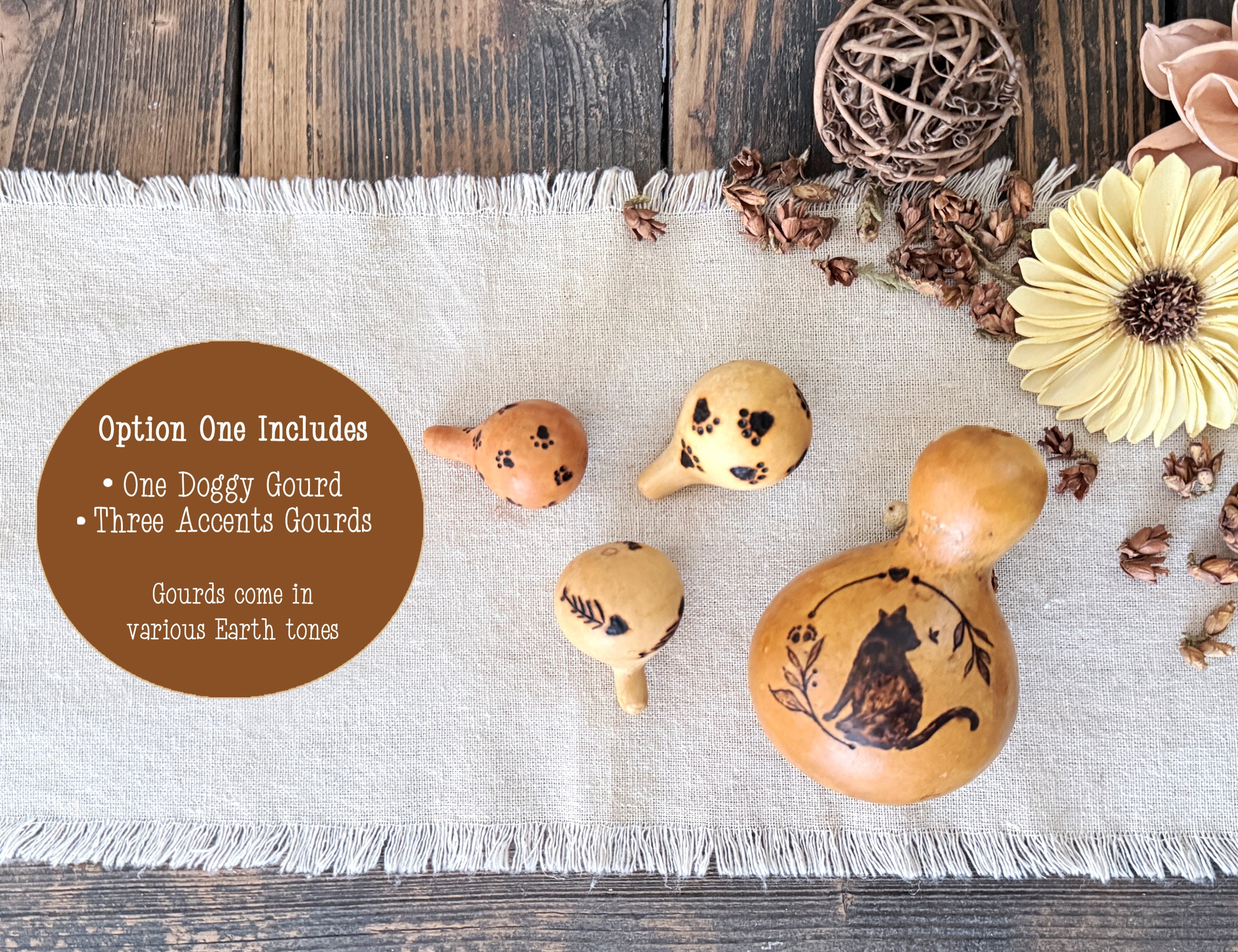 Decorative gourds with cat design on a textured surface with flowers and twine.