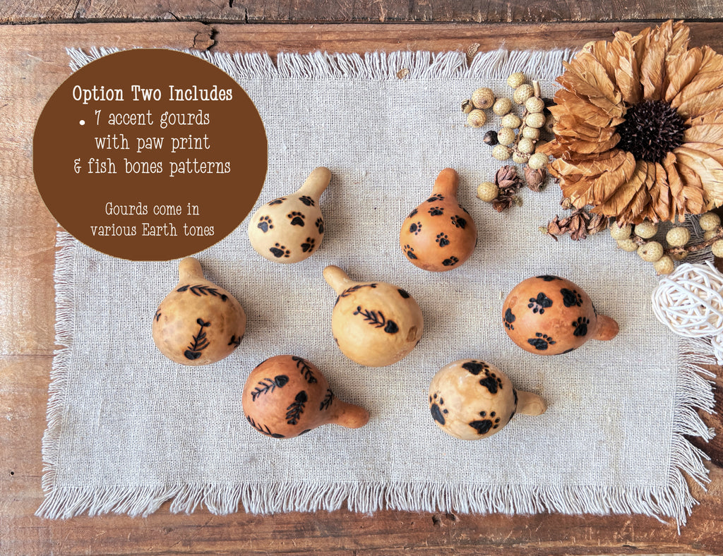 Decorative gourds with paw print and fish bone patterns on a textured surface.