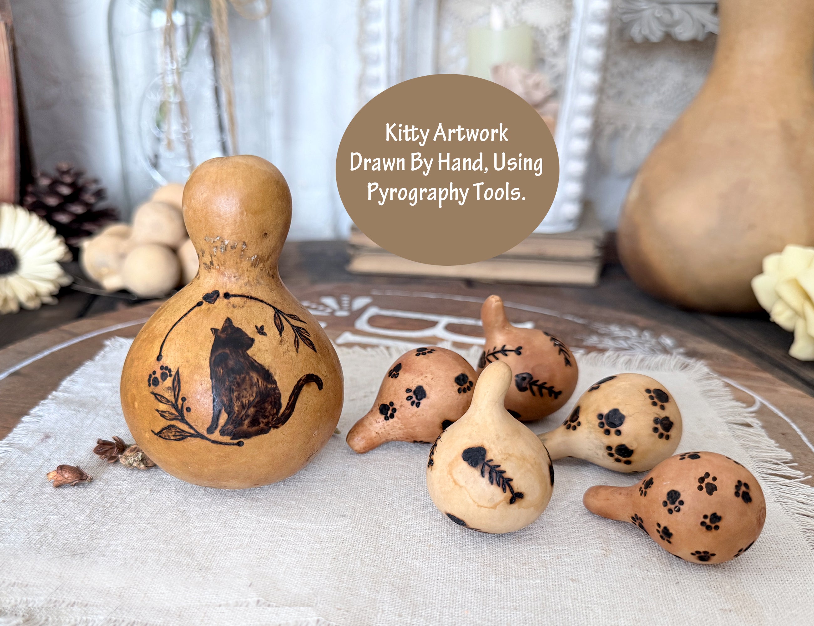 Decorative gourds with pyrography designs on a textured surface.