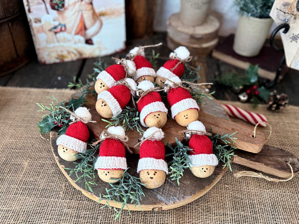 Several mini and Santa gourds are laid out on a vintage bread board. Faux sprigs of rosemary are  tucked in between them 
