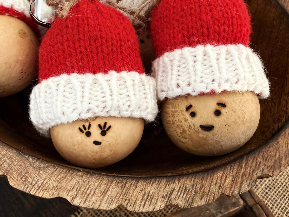Close up image of Santa gourd bowl fillers. Each has a cute, simple facial expression. 