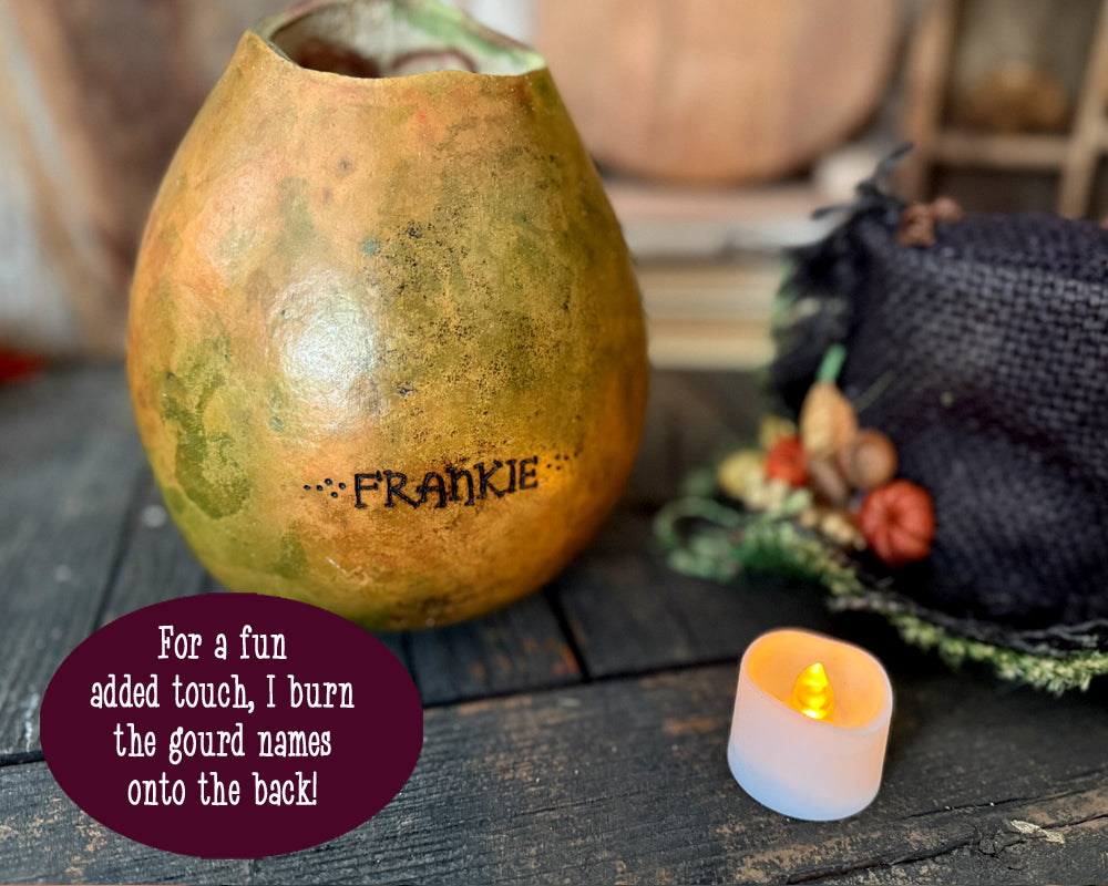 green stained gourd shown from the back. The name Frankie is engraved into the gourds shell. 