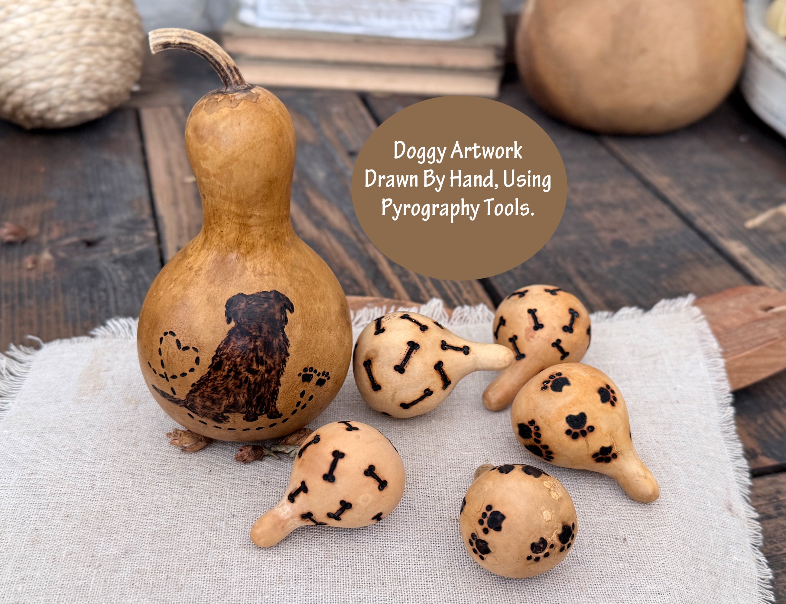 Decorative dog gourds with pyrography designs on a wooden surface