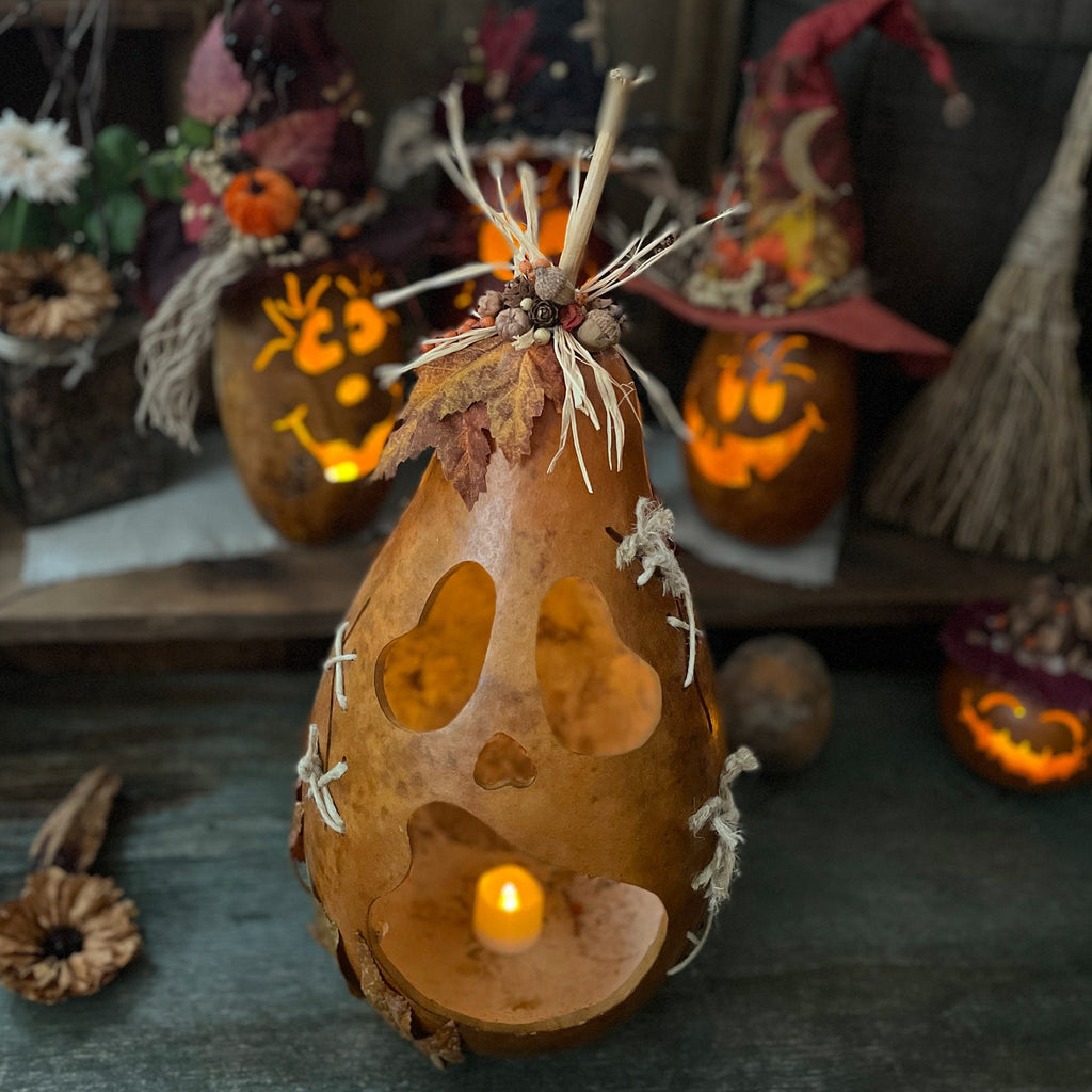 Decorative gourd with a candle inside, surrounded by Halloween-themed decorations.