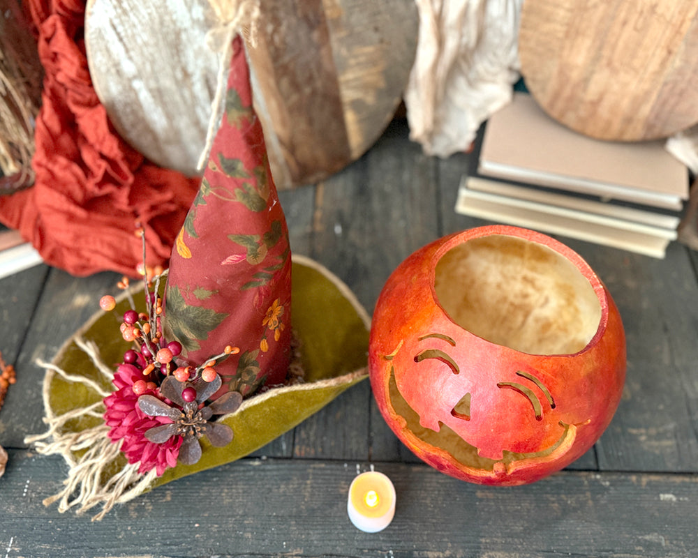 Decorative items including a pumpkin lantern on a wooden surface.