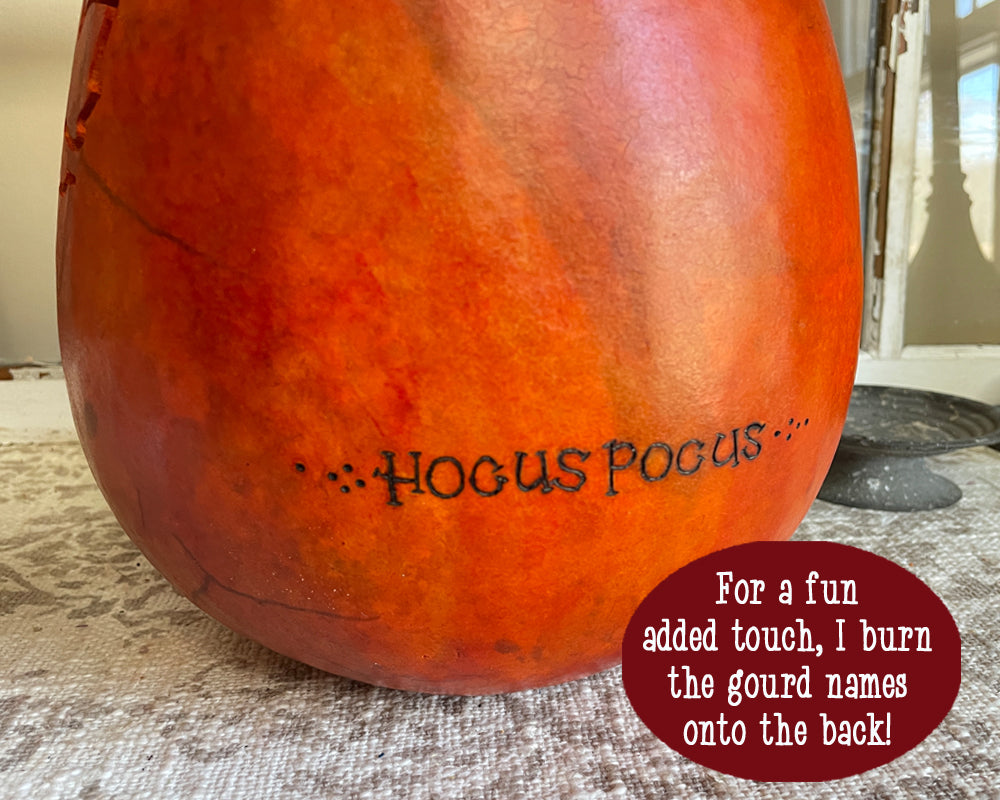 Decorative gourd with 'HOCUS POCUS' text on a textured surface