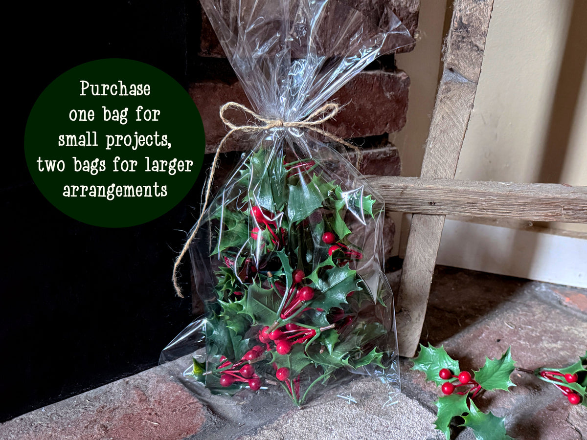 A clear bag of  faux holly berry greenery.