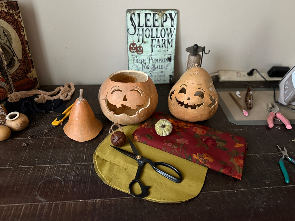 Halloween-themed items including carved pumpkins and tools on a table with a 'Sleepy Hollow Farm' sign.