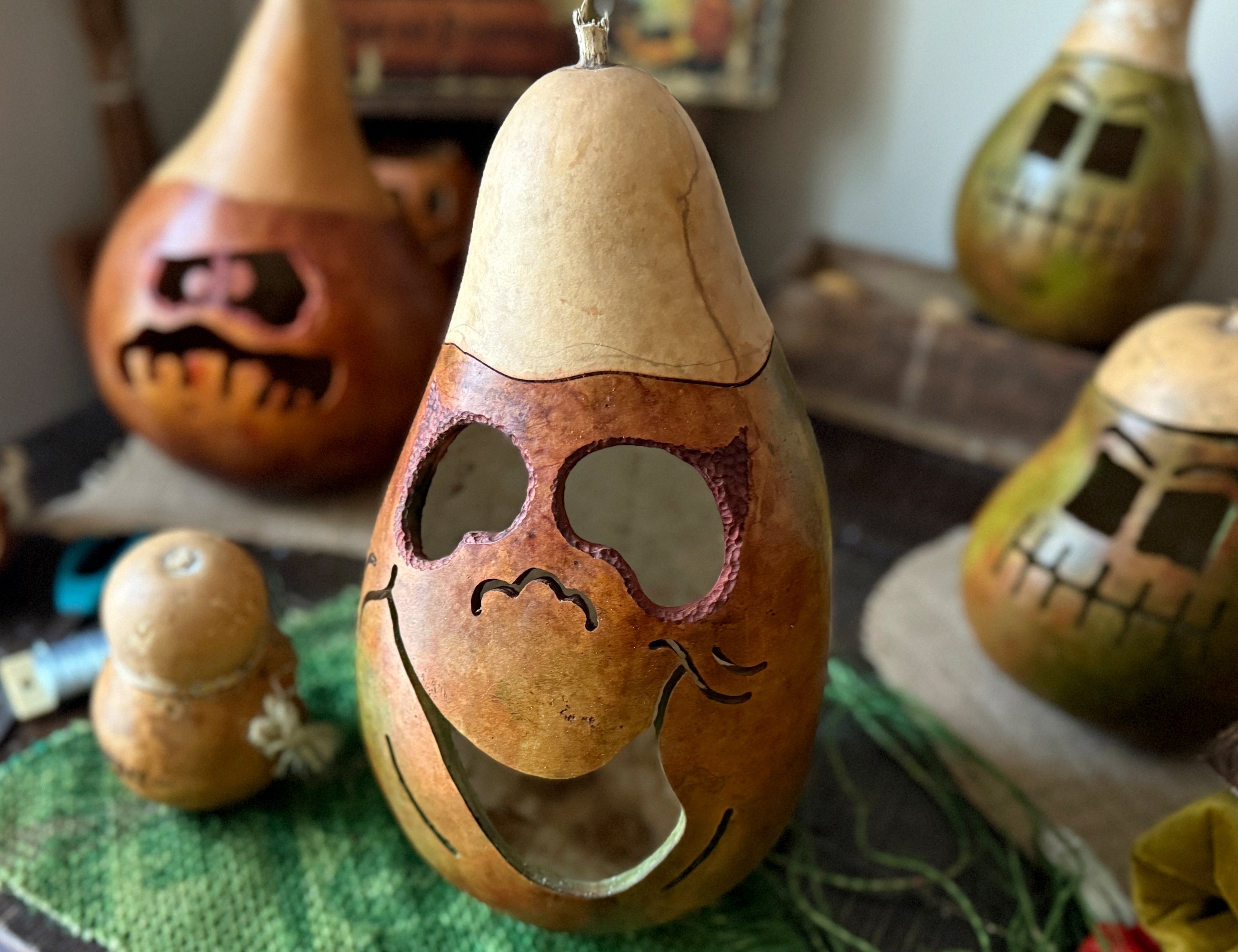 Decorative gourds with carved faces on a table