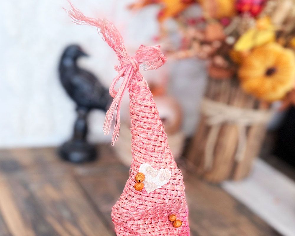 The top of the witch hat made from pink burlap with a bow tied at the tip