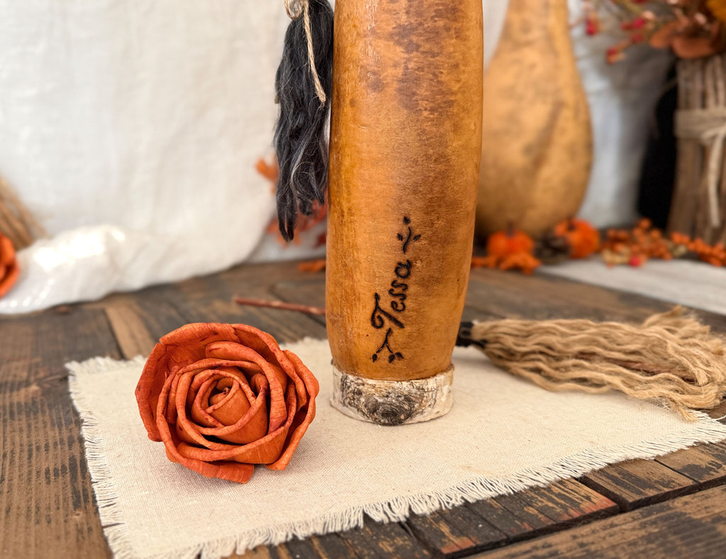 A close up view of the witch gourds personalized name engraved on the bottom left of her body. Her name is Tessa.